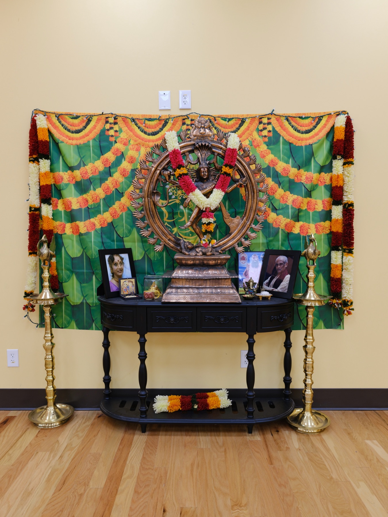 Shrine to Lord Nataraja with marigold garlands and brass lamps