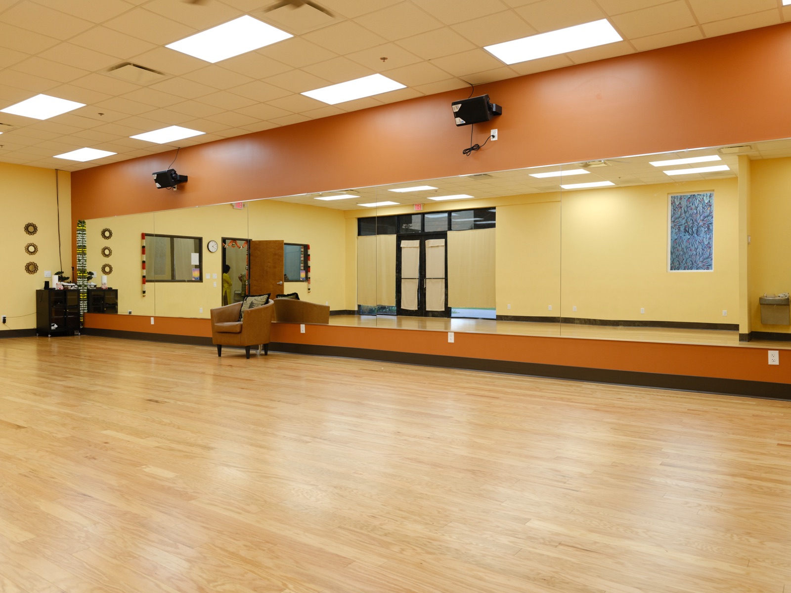 Interior dance studio with sprung wood floor and full mirror wall